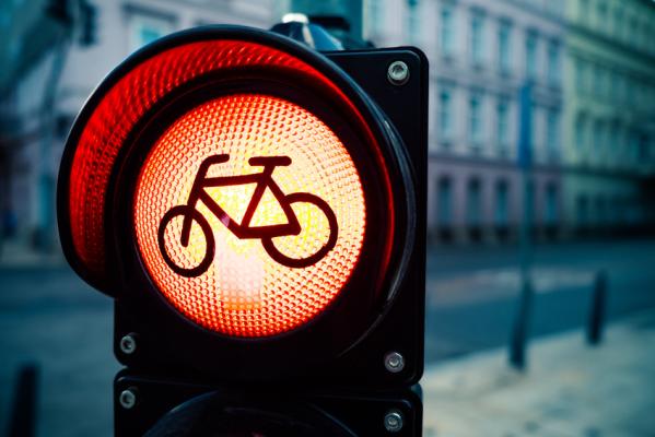 Red traffic light with bicycle sign with urban buildings in blurred background