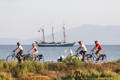 Radfahrer an der Kste der Toskana mit Schiff Atlantis