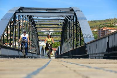 Radfahrer beim Überqueren des Douro über die Peso da Regua Brücke 