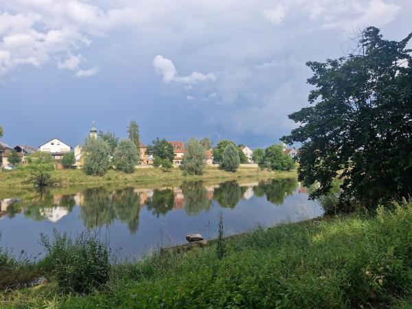 Flusslandschaft und Blick auf ein Dorf