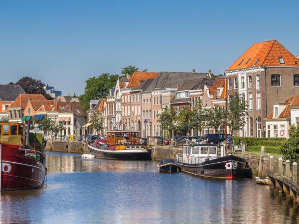 Panorama of a canal with old ships and historical houses in Zwolle