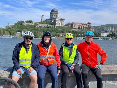 Gl�ckliche Radreisende sitzend an der Donau mit Kathedrale von Esztergom im Hintergrund