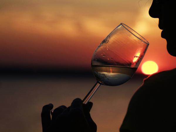 Ein Glas Wein am bei Sonnenuntergang am Neusiedler See