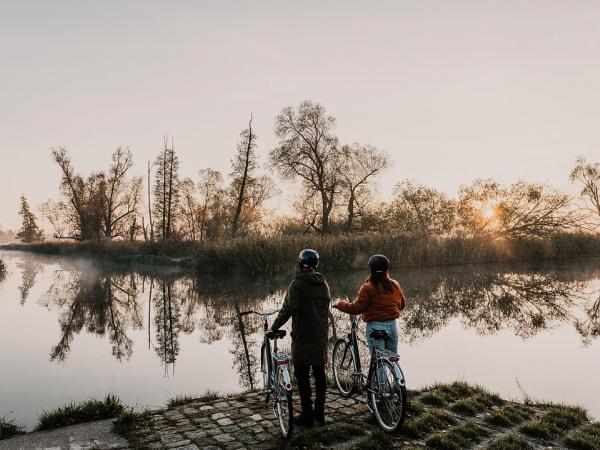 Radfahrer im Sonnenaufgang an der Spree