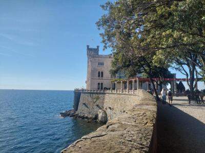 Schloss am azurblauen Meer mit B�umen im Vordergrund und tiefblauem Himmel