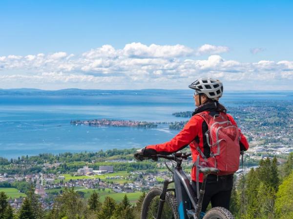 Radfahrerin blickt auf den Bodensee von Anhhe