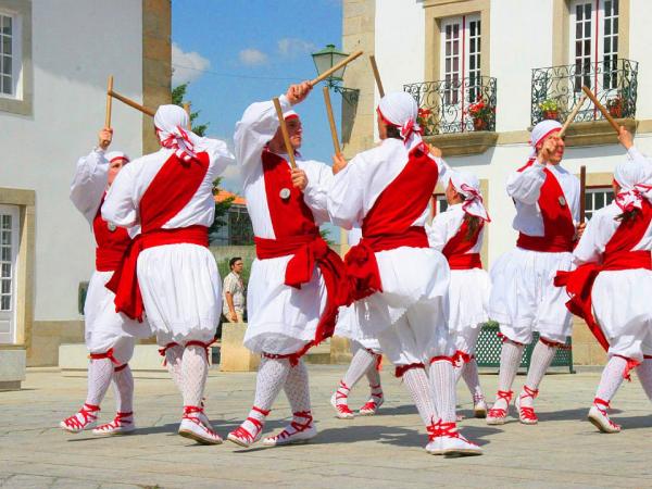 Folkloregruppe aus Portugal tanzend auf der Strae, in rot weien Kostmen
