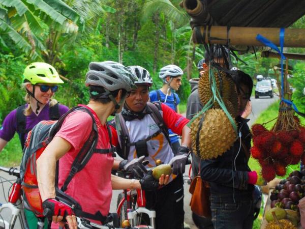 Radfahrer kaufen auf Bali frische Frchte am Wegesrand